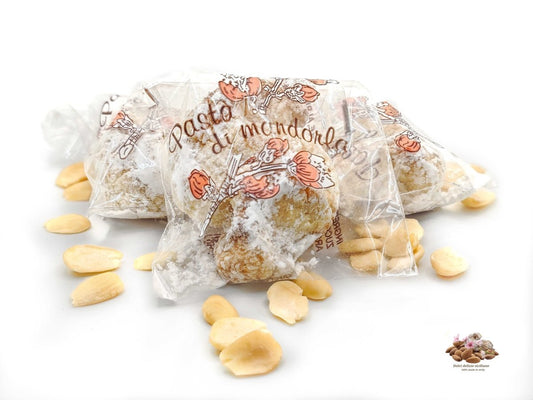 Foto con tre biscotti alle mandorle con zucchero a velo, imbustati uno ad uno dolci delizie siciliane
